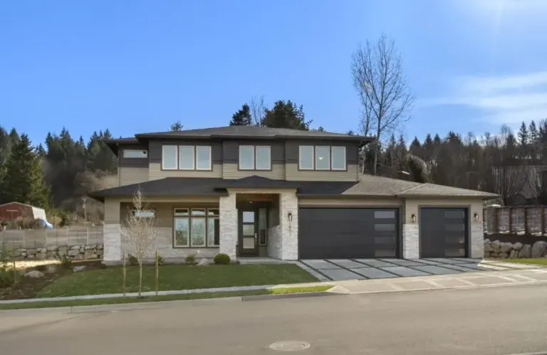 Two-story custom home exterior with stone and dark wood siding, three-car garage, and large windows - Marnella Homes Mordano Verona Collection